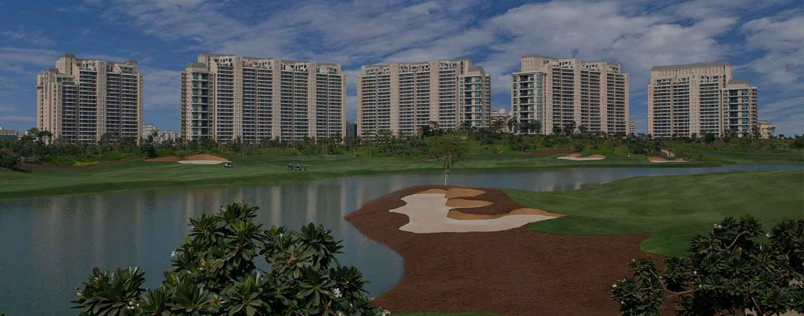 Residential towers reflected across a golf course water hazard