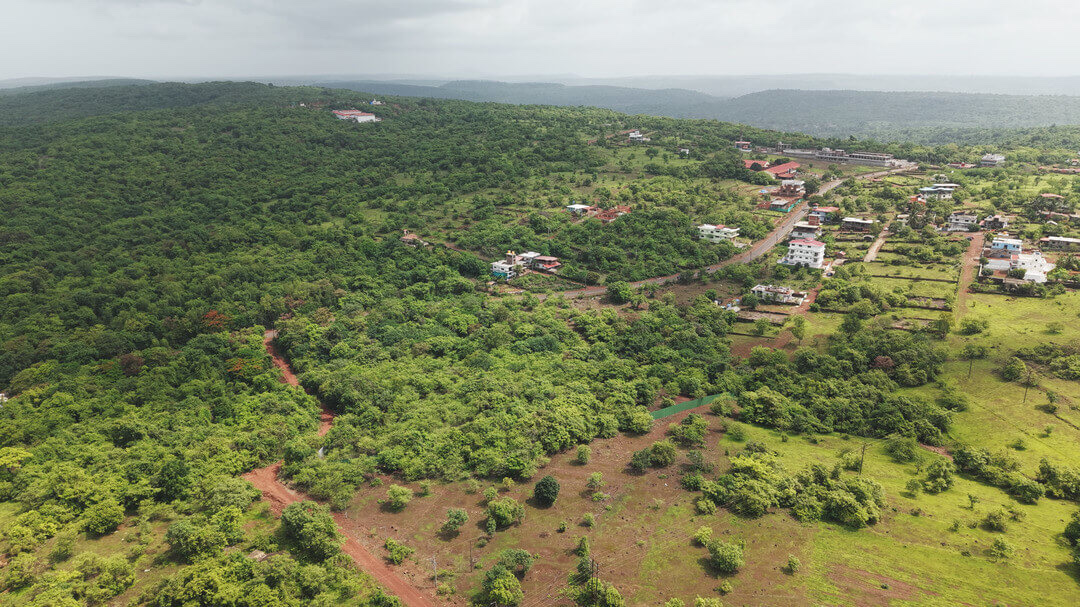 Green hillside and village around the Corvero site in Pernem